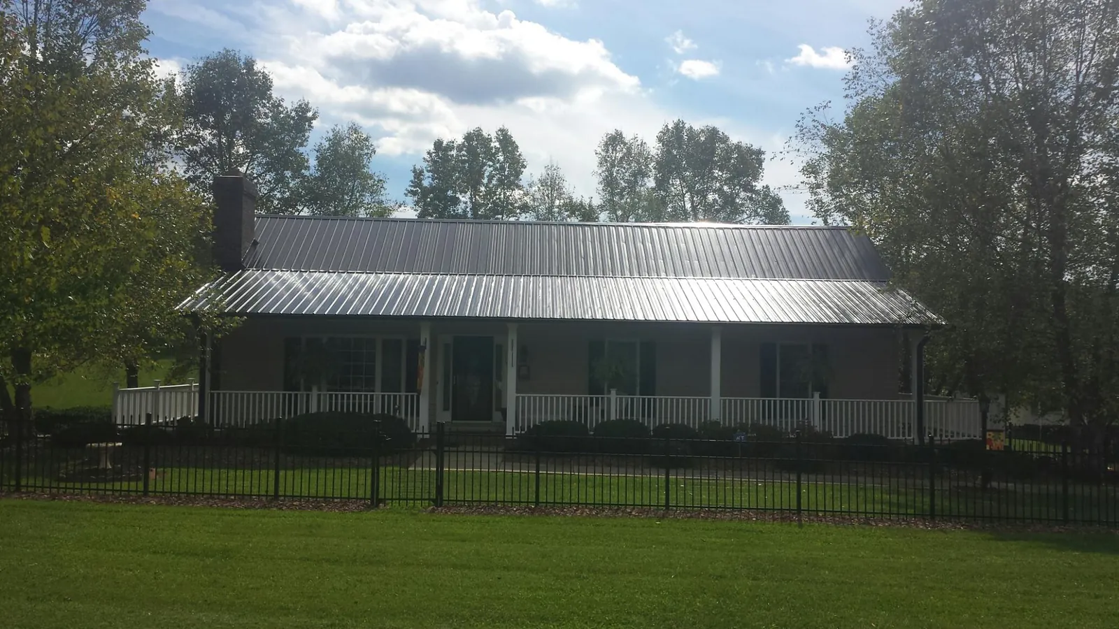 Gray metal roof on a brick ranch with a full width front porch — Gutter Guard Installation work by our crew in Fort Mitchell